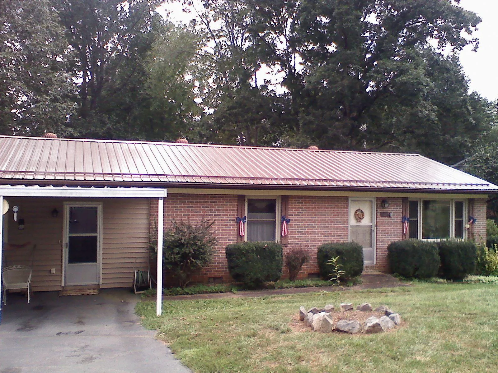 Bronze metal roof and carport on a brick ranch home — Roof Repair work by our crew in Earlham
